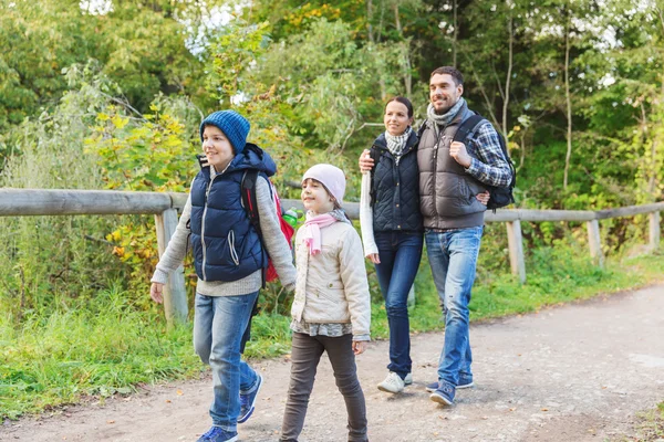 Família feliz com mochilas caminhadas na floresta — Fotografia de Stock