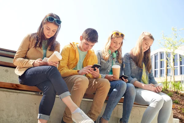 Amigos adolescentes con teléfono inteligente y tazas de café — Foto de Stock