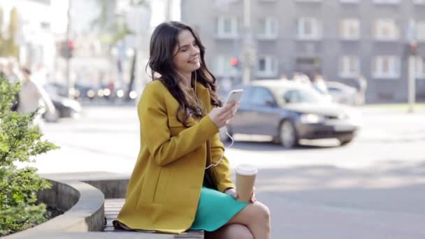 Gelukkig jonge vrouw met smartphone en hoofdtelefoons — Stockvideo