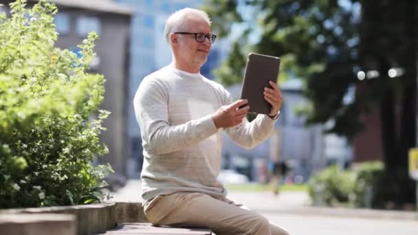 Uomo anziano avendo videochiamata su tablet pc in città — Video Stock