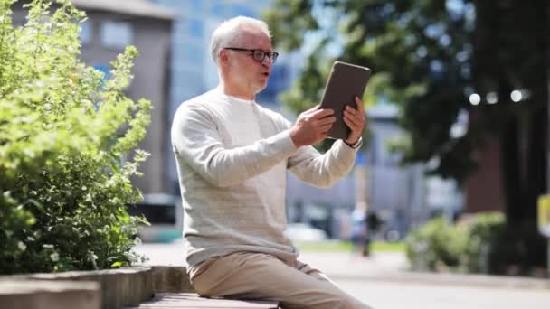 Äldre man att ha videosamtal på TabletPC i city — Stockvideo