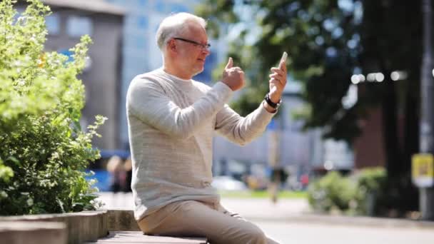 Старший мужчина с видеозвонком на смартфон в городе — стоковое видео