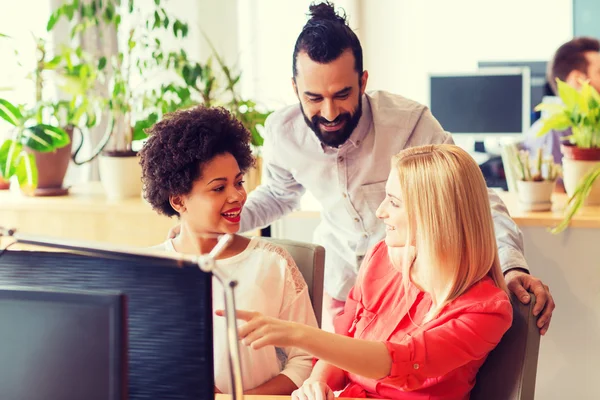 Glückliches Kreativteam mit Computer im Büro — Stockfoto