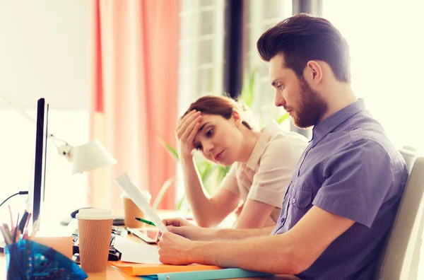 Équipe créative avec papier de lecture au bureau — Photo