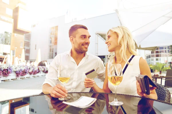 Casal feliz com carteira pagar conta no restaurante — Fotografia de Stock