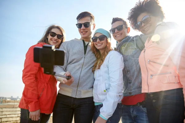 Amigos sonrientes tomando selfie con teléfono inteligente —  Fotos de Stock