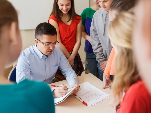 Group of students and teacher with tests at school — Stock Photo, Image