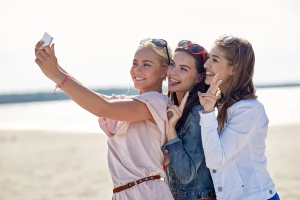 Grupo de mujeres sonrientes tomando selfie en la playa —  Fotos de Stock