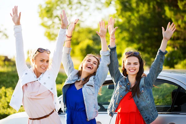 Счастливые девочки-подростки или женщины рядом с машиной на обочине — стоковое фото