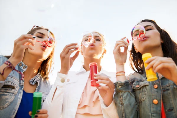 Young women or girls blowing bubbles outdoors — Stock Photo, Image