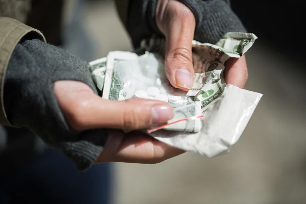 Primo piano delle mani dei tossicodipendenti con droga e denaro — Foto Stock