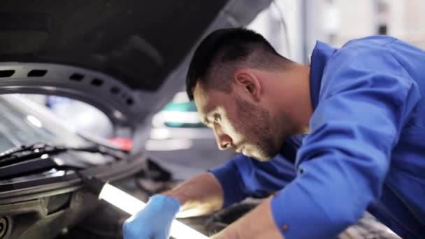 Mekaniker man med skiftnyckel reparera bil på verkstaden — Stockvideo