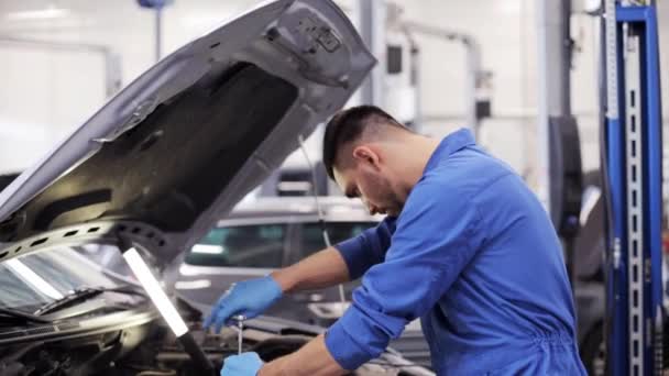 Monteur met moersleutel reparatie auto op de werkplaats — Stockvideo