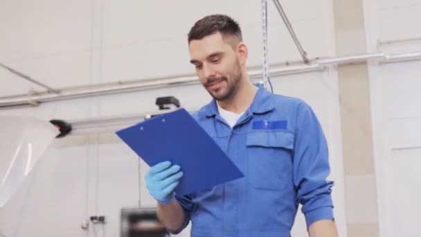 Mechanic man with clipboard at car workshop — Stock Video