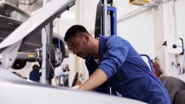 Mécanicien homme avec lampe réparation voiture à l'atelier — Video