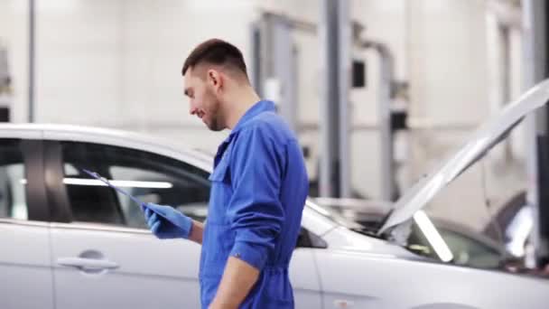 Homem mecânico com prancheta na oficina de carro — Vídeo de Stock