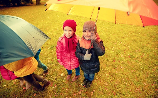 Happy children with umbrella in autumn park — Zdjęcie stockowe