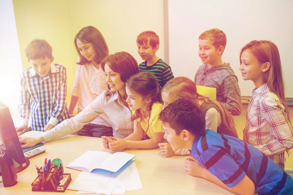 Group of kids with teacher and computer at school — Stock Photo, Image