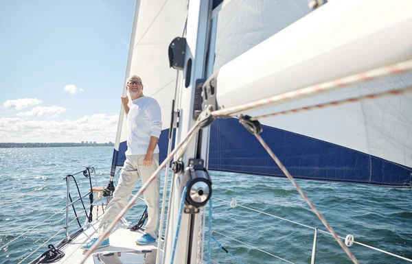 Старший чоловік на вітрильному човні або яхті, що пливе в морі — стокове фото