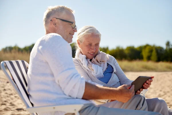 Felice coppia anziana con tablet pc sulla spiaggia estiva — Foto Stock