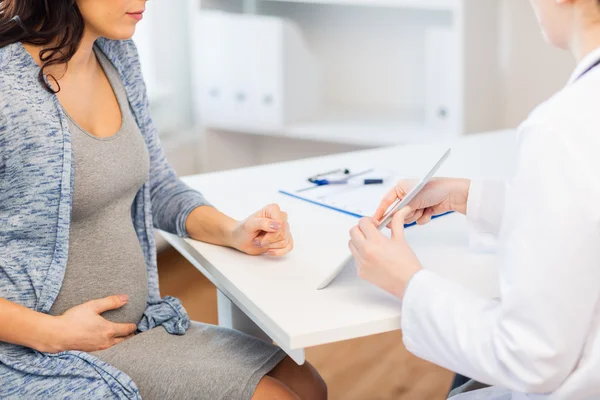 Perto do médico com comprimido e mulher grávida — Fotografia de Stock