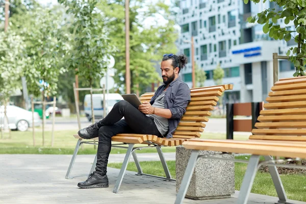 Hombre con la tableta de la PC sentado en la ciudad banco de la calle — Foto de Stock