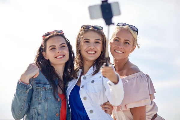 Grupo de mujeres sonrientes tomando selfie en la playa — Foto de Stock