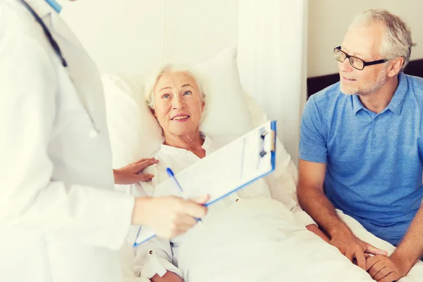 Femme âgée et médecin avec presse-papiers à l'hôpital — Photo