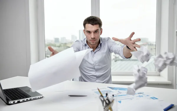 Разгневанный бизнесмен бросает бумаги в офис — стоковое фото