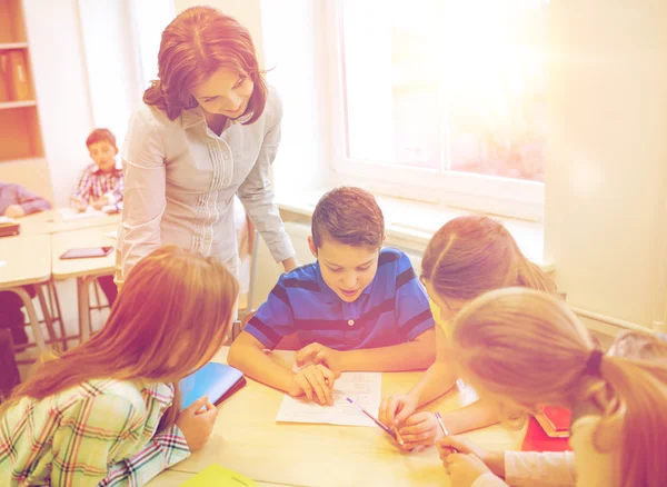 Group of school kids writing test in classroom — Stock Photo, Image