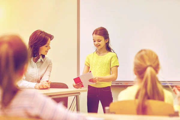 Group of school kids with teacher in classroom — Stock Photo, Image