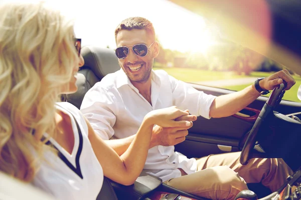 Feliz hombre y mujer conduciendo en coche cabriolet — Foto de Stock