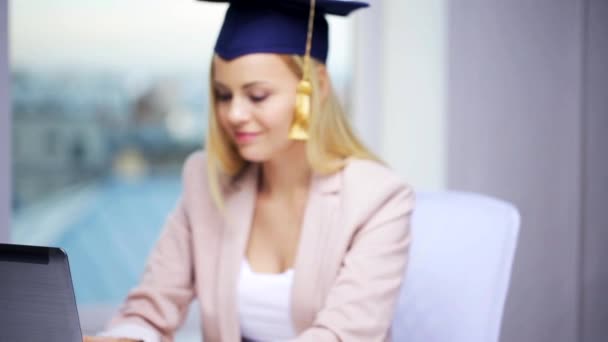 Étudiante fille en bonnet de célibataire montrant diplôme — Video