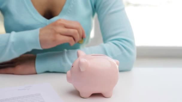 Vrouw een euromunt ingebruikneming piggy bank — Stockvideo