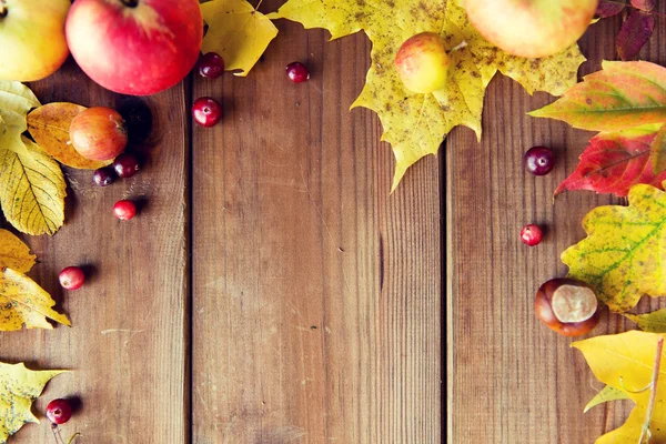 Frame of autumn leaves, fruits and berries on wood — Stock Photo, Image