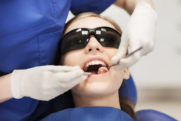 Dentista femenino chequeando dientes de niña paciente —  Fotos de Stock