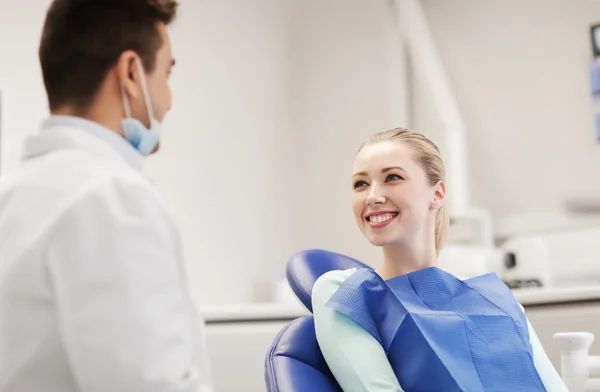 Dentista masculino feliz com paciente mulher na clínica — Fotografia de Stock