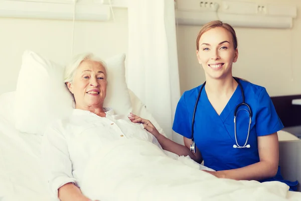 Médico o enfermero que visita a una mujer mayor en el hospital — Foto de Stock