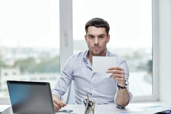 businessman showing blank paper card at office