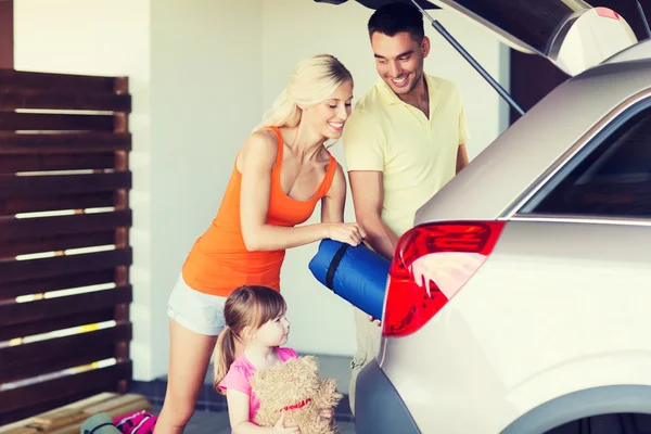 Família feliz embalando coisas para o carro em casa estacionamento — Fotografia de Stock