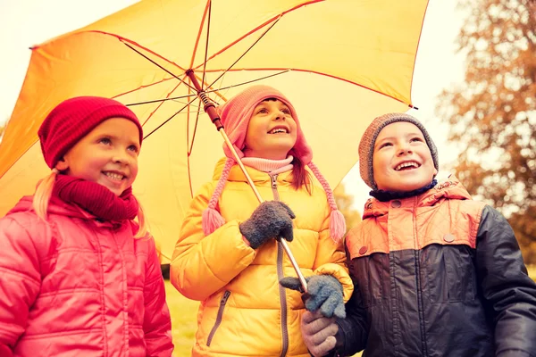 Happy children with umbrella in autumn park — 图库照片