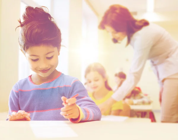 Heureuse petite écolière sur fond de classe — Photo