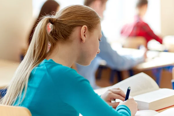 Gros plan de l'élève avec livre écrit test de l'école — Photo