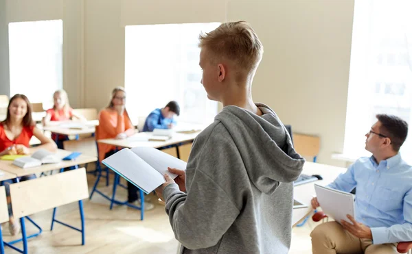 Élève garçon avec ordinateur portable et enseignant à l'école — Photo
