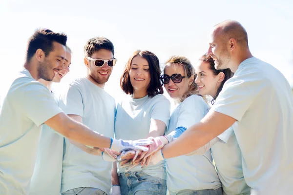 Grupo de voluntários colocando as mãos no topo no parque — Fotografia de Stock