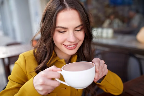 都市通りのカフェでココアを飲んで幸せな女 — ストック写真