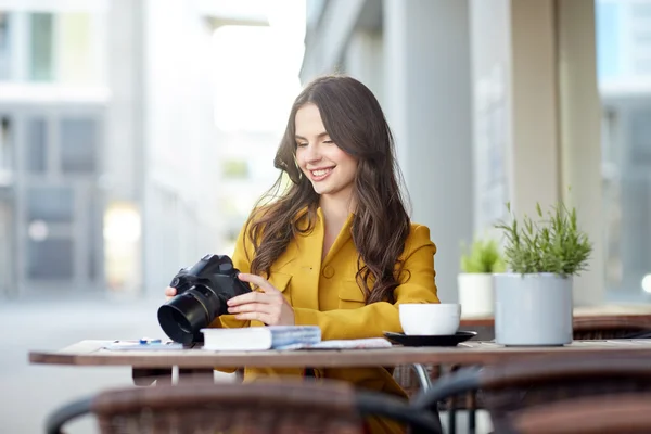 Femme touristique heureuse avec caméra au café de la ville — Photo