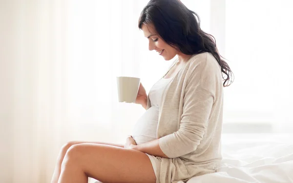 Mulher grávida feliz com xícara beber chá em casa — Fotografia de Stock
