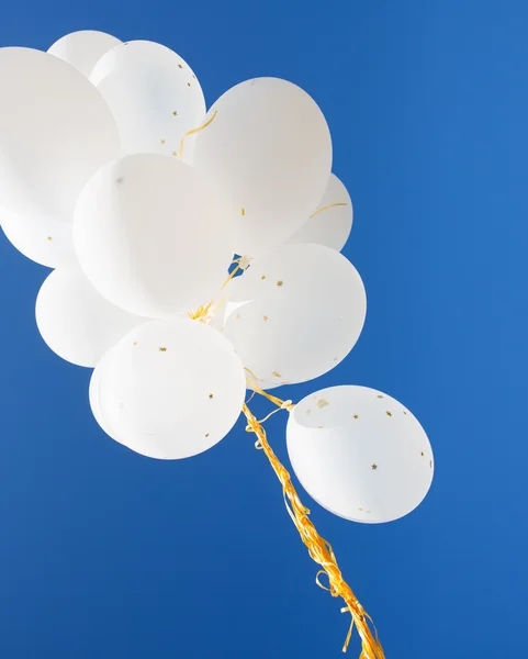 白色的氦气球在蓝蓝的天空中的特写 — 图库照片