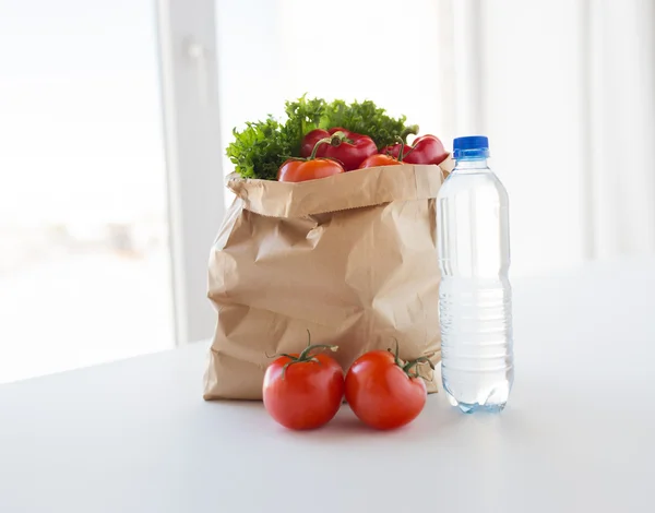 Cesta de legumes frescos e água na cozinha — Fotografia de Stock